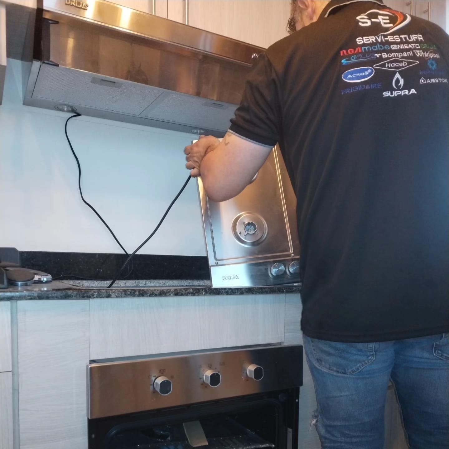 Técnico instalando horno empotrable y campana extractora